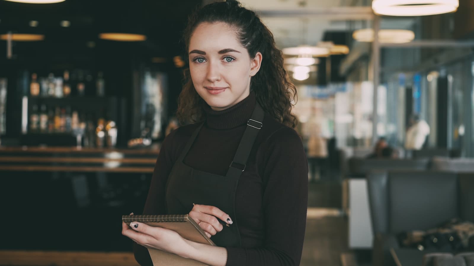 Young worker in an apron using a tablet