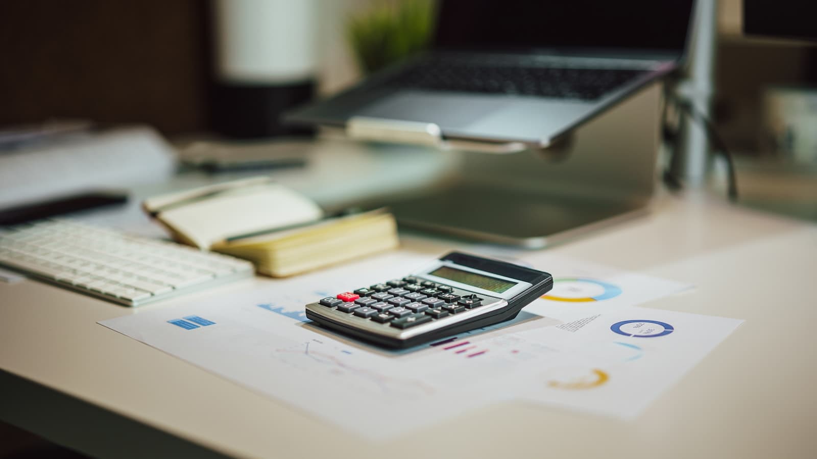 Calculator and laptop set up on a desk for tax preparation